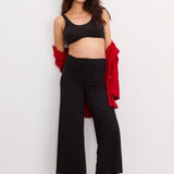 Black maternity crop pants with wide legs, soft stretchy fabric, worn with a black crop tank and red cardigan draped over.